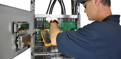 tech performing preventative maintenance to telecom batteries